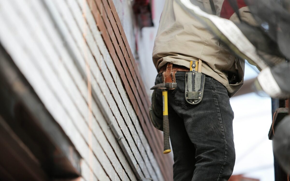Bauarbeiter auf Baustelle mit Werkzeug Holz im Hintergrund Bauarbeiter auf Baustelle mit Werkzeug Holz im Hintergrund